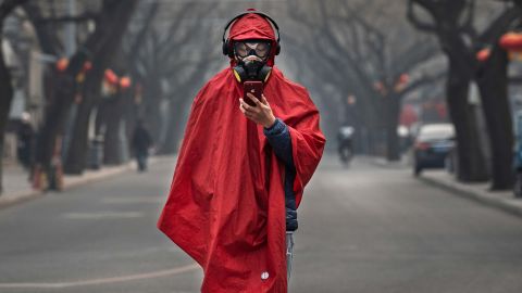 A Chinese man wears a protective mask as he stands in a nearly empty street in Beijing on January 26. 