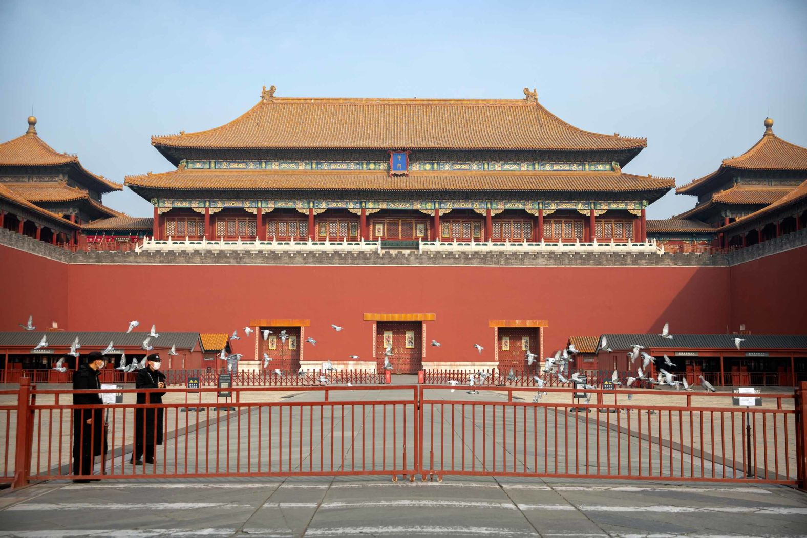 Security officials stand near the closed gates at the entrance to the Forbidden City. Cultural landmarks have closed their doors to visitors due to the outbreak.