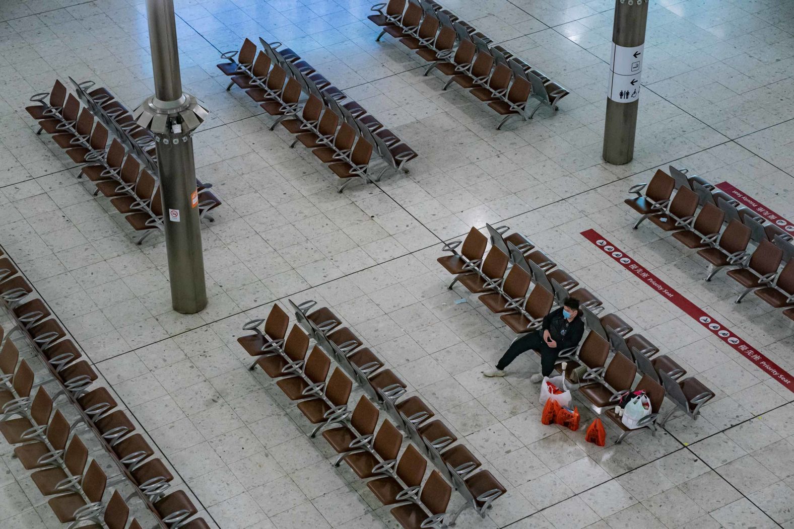 A lone traveler sits at a gate in the Hong Kong High Speed Rail Station on January 29. The Hong Kong government said it will tighten international travel and border crossings to stop the spread of the virus.