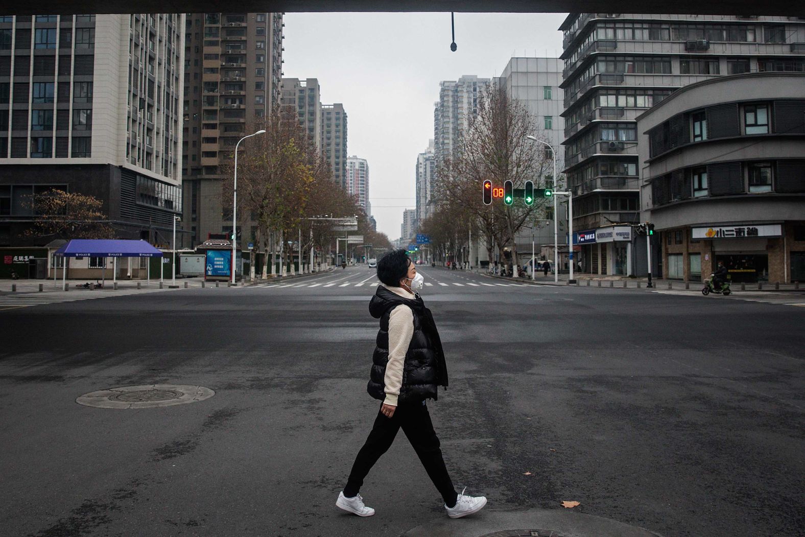 A woman crosses an empty road on January 27 in Wuhan.