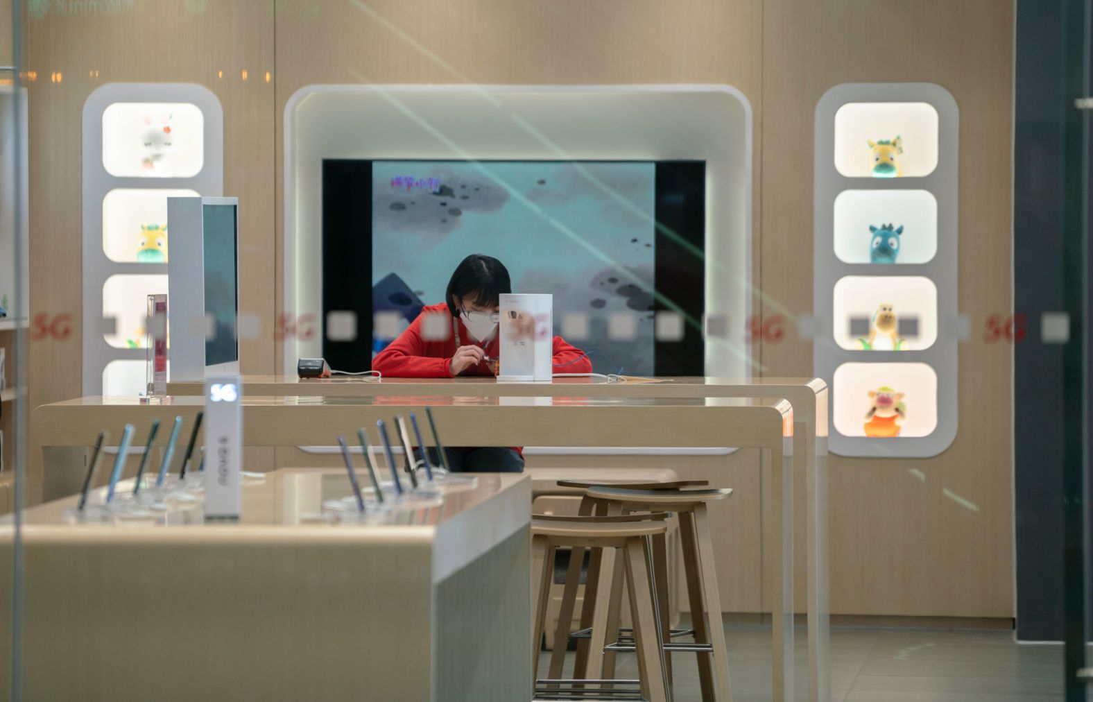 A salesperson sits in an empty shop at a mall in Tianjin on January 25.