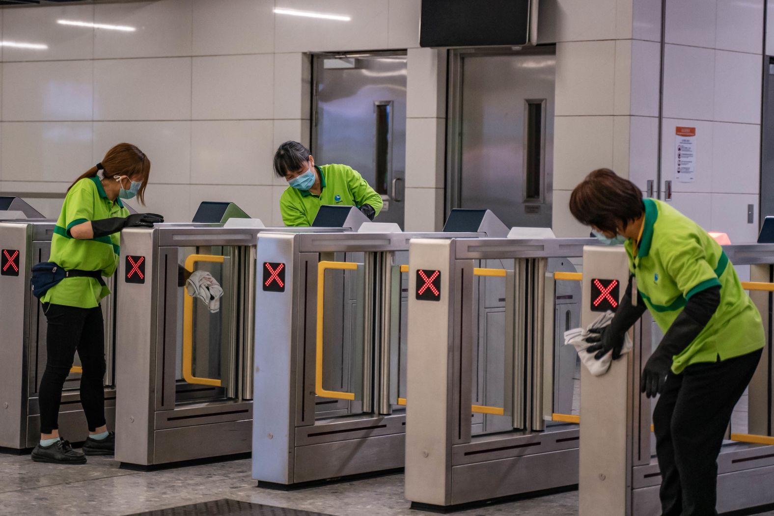 Cleaners wipe down gates in the arrival hall at Hong Kong High Speed Rail Station on January 29.