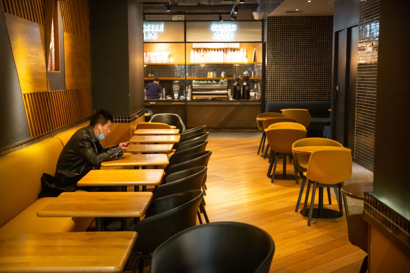 A restaurant patron waits for his food in an empty restaurant in Beijing.