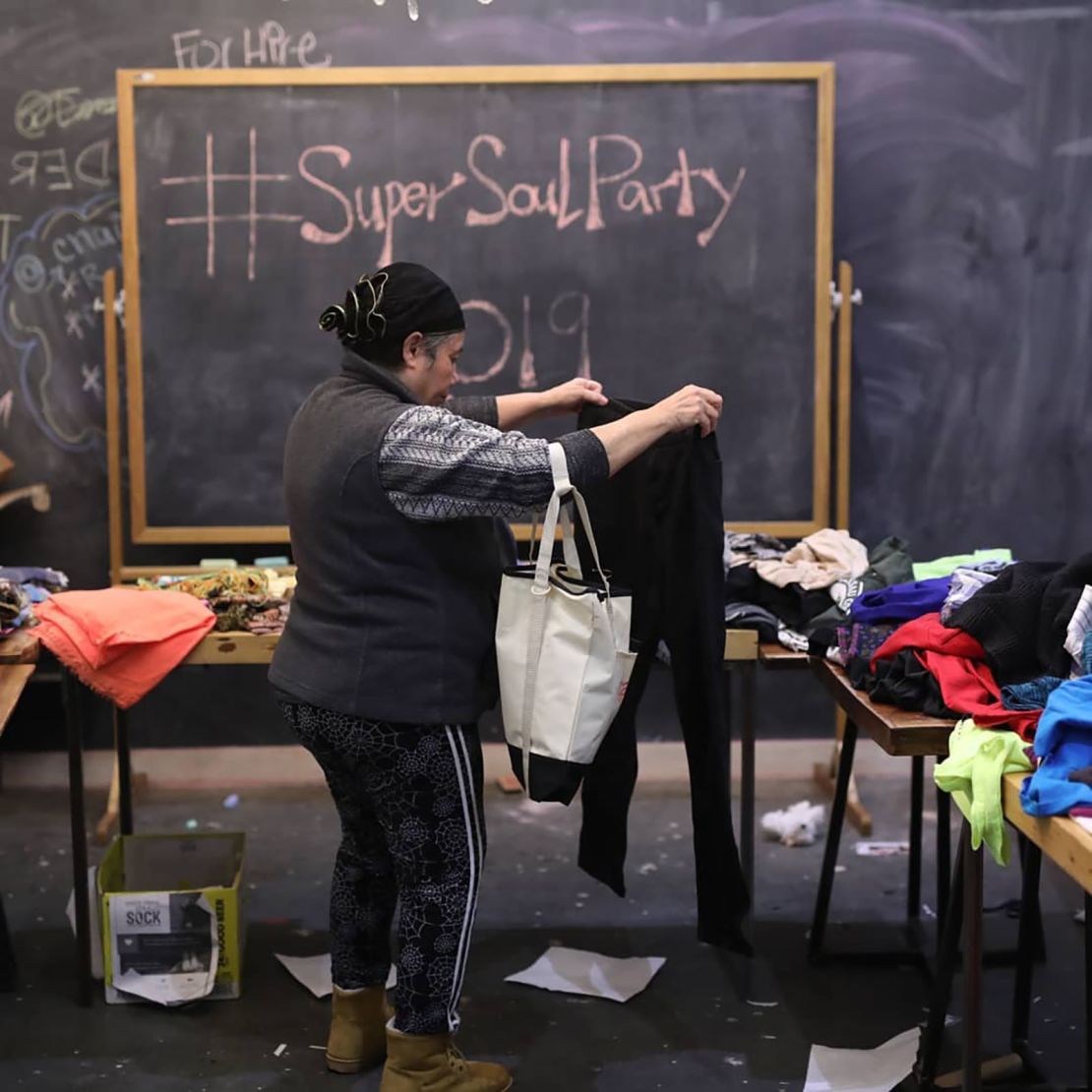 A guest rummages through a clothing drive table at a 2019 Super Soul Party.