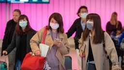 Passengers wear protective masks to protect against the spread of the Coronavirus as they arrive at the Los Angeles International Airport, California, on January 22, 2020. 
