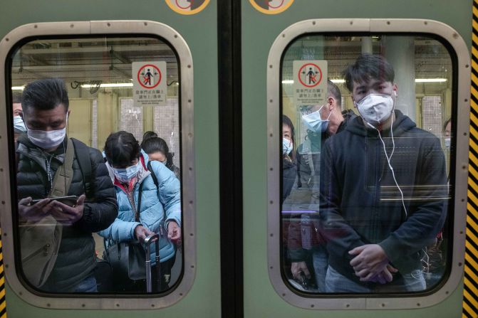 Passengers in Hong Kong wear protective masks as they wait to board a train at Lo Wu Station, near the mainland border.
