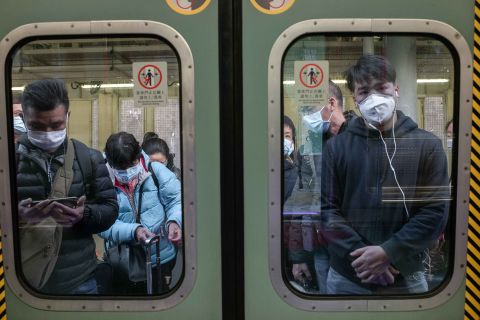 Passengers in Hong Kong wear protective masks as they wait to board a train at Lo Wu Station, near the mainland border, on January 30. 