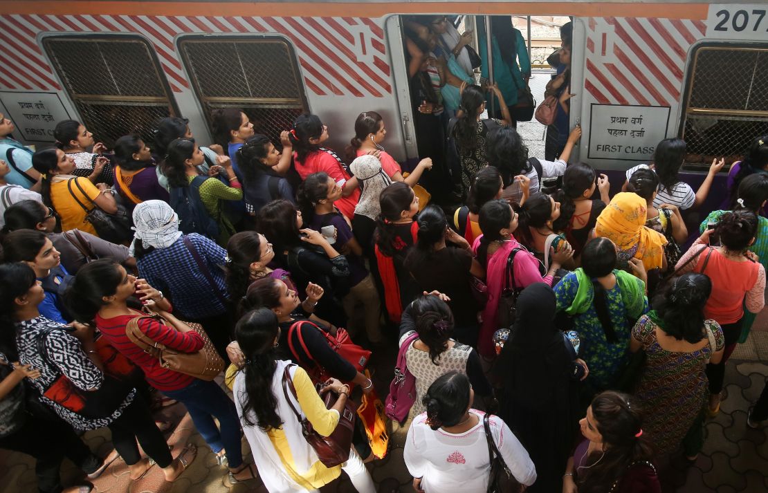 Indian women board an overcrowded local train on July 10, 2014. 
