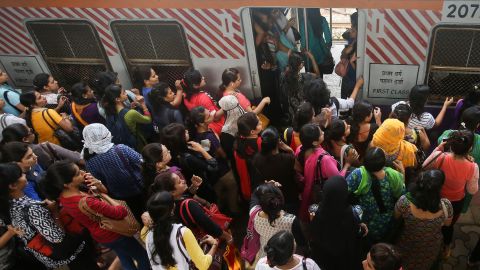 Indian women board an overcrowded local train on July 10, 2014.