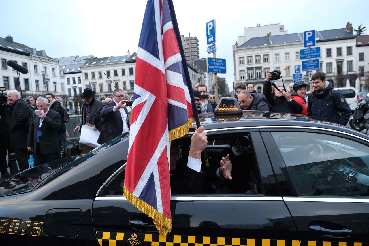 Jonathan Bullock, a Brexit Party member of the European Parliament, holds a flag as he leaves Brussels to return to Britain.