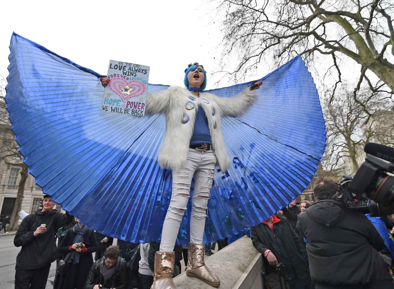 An anti-Brexit demonstrator spreads her wings during a gathering near Downing Street in London.