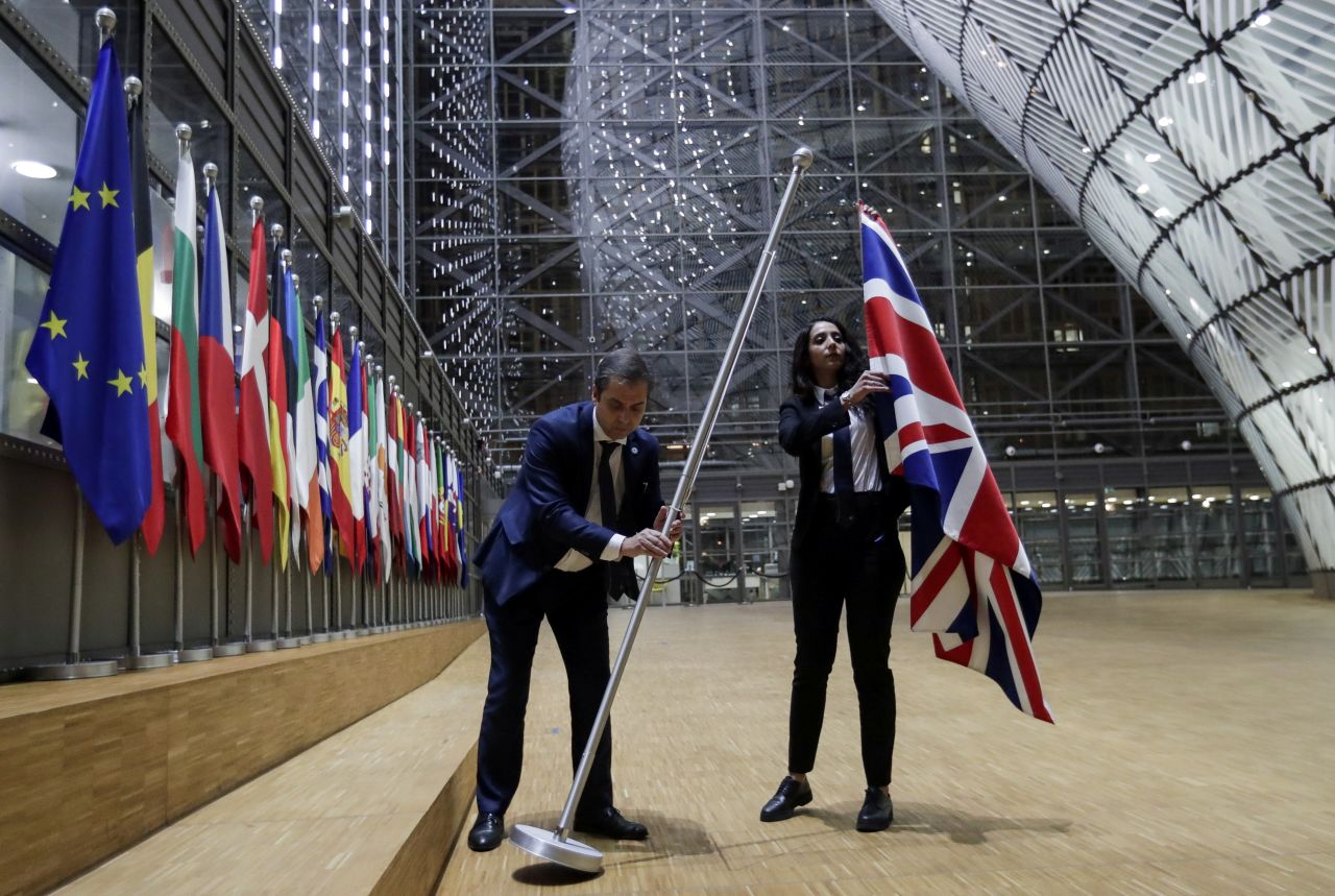 Officials remove the British flag at the European Union Council in Brussels, Belgium.