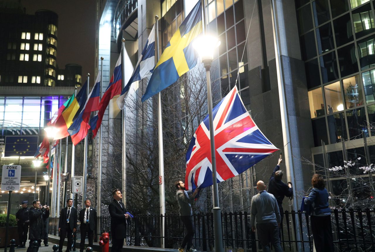 Staff members take down the United Kingdom's flag from outside the European Parliament building in Brussels.