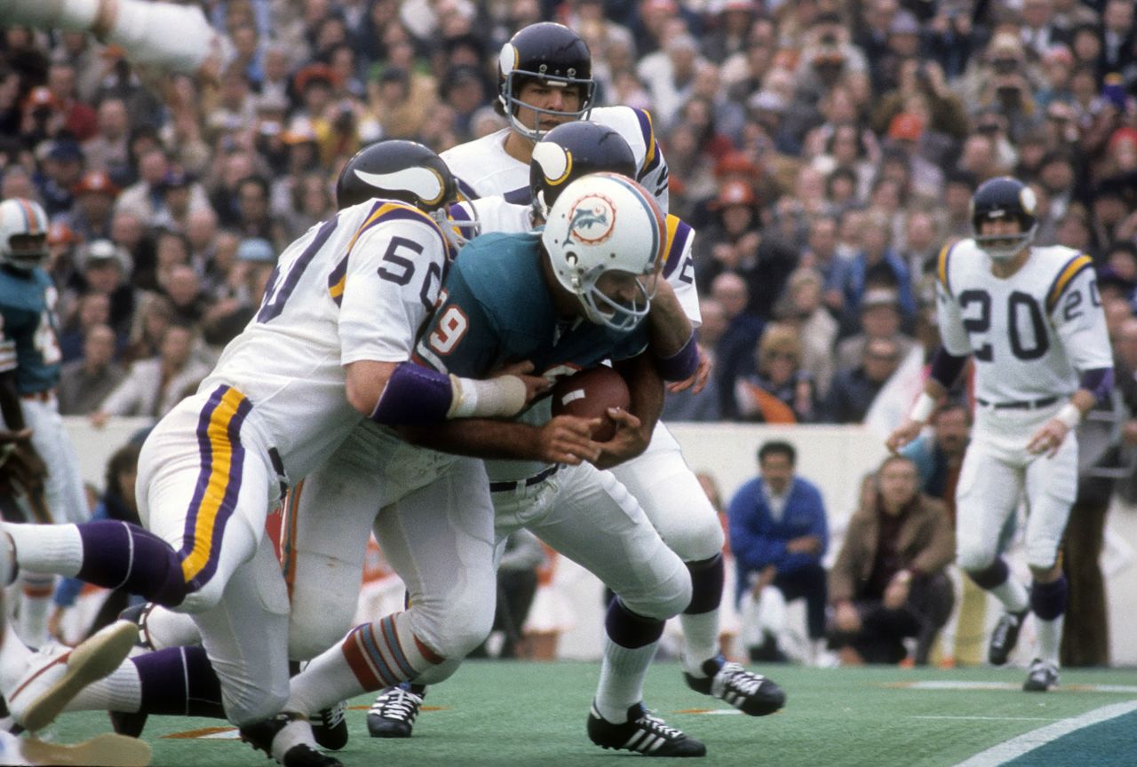 <strong>Super Bowl VIII (1974):</strong> Powerful running back Larry Csonka carries two Minnesota defenders near the end zone as Miami won its second Super Bowl in a row. Csonka became the first running back to win Super Bowl MVP, rushing for 145 yards and two touchdowns.