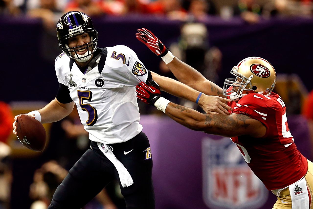 <strong>Super Bowl XLVII (2013):</strong> Baltimore Ravens quarterback Joe Flacco fights off San Francisco linebacker Ahmad Brooks during Super Bowl XLVII, which the Ravens won 34-31. Flacco had 287 yards and three touchdowns in a game that was interrupted for 34 minutes because of a power outage.