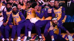 Los Angeles Lakers' LeBron James, center, and Quinn Cook wipe their faces while watching a video tribute to Kobe Bryant, before the Lakers' NBA basketball game against the Portland Trail Blazers in Los Angeles, Friday, Jan. 31, 2020.