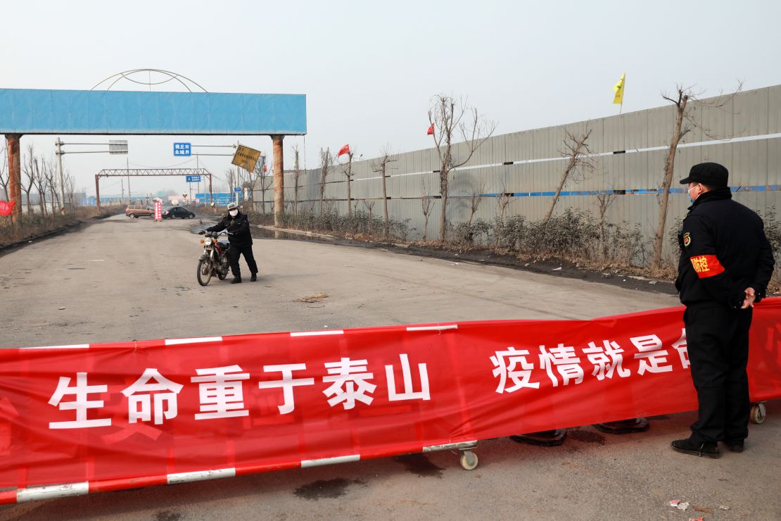 A motorbiker turns around at a road blockage and checkpoint in Huaibei in central China's Anhui province on January 29.