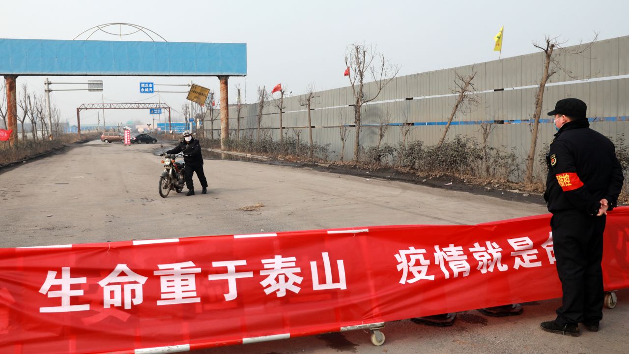 A motorbiker turns around at a road blockage and checkpoint in Huaibei in central China's Anhui province on January 29.