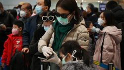 A woman wears a protective face mask and gloves while waiting to go through immigration at Beijing airport on February 1, 2020. - China faced deepening isolation over its coronavirus epidemic on February 1 as the death toll soared to 259, with the United States leading a growing list of nations to impose extraordinary Chinese travel bans. (Photo by GREG BAKER / AFP) (Photo by GREG BAKER/AFP via Getty Images)