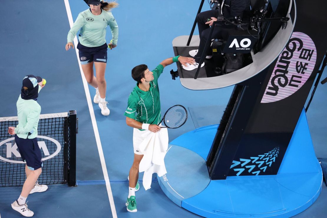 Djokovic pats the feet of the umpire in a heated exchange. 