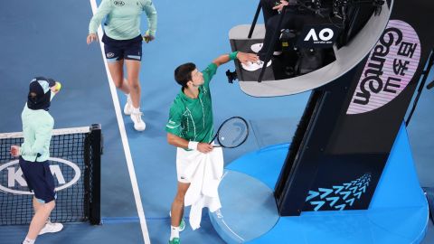 Djokovic pats the feet of the umpire in a heated exchange. 