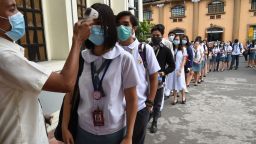 Students wearing protective face masks have their temperatures taken while entering their college campus in Manila on January 31, 2020. - The Philippines reported its first case of the virus on January 30, a 38-year-old woman who arrived from Wuhan and is no longer showing symptoms. (Photo by Ted ALJIBE / AFP) (Photo by TED ALJIBE/AFP via Getty Images)