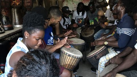 Scholars drumming with artisans from the Arts Centre Market in Accra, Ghana.