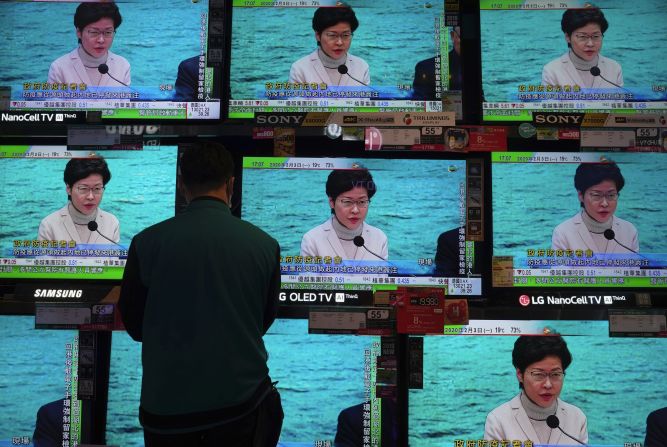 A man stands in front of TV screens broadcasting a speech by Hong Kong Chief Executive Carrie Lam on February 3, 2020. Lam said the city would shut almost all border-control points to the mainland.