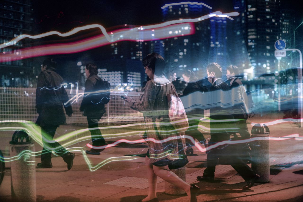 A crowd of busy Tokyoites rush by as the ripples reflected on Enomoto's wet windscreen streak past them like strobe lights.