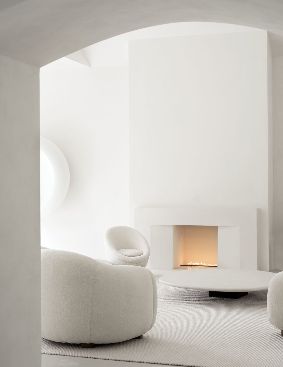 Upholstered seating by Royere and a limestone cocktail table by Vervoordt grace the living room.