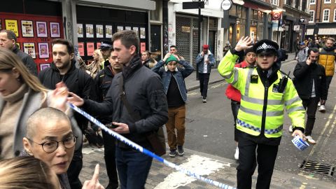 Police leave a cordoned off area in Soho on Monday.