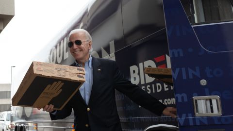Biden carries pizza boxes before speaking at an event in Des Moines on February 3.