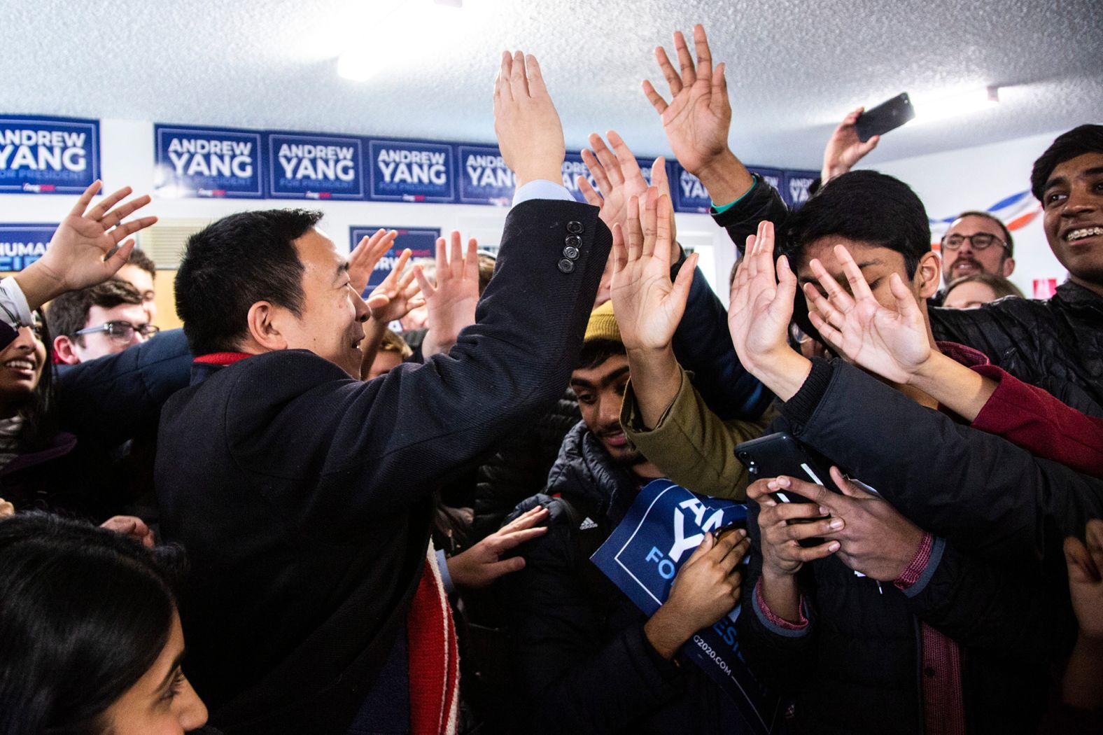 Andrew Yang high-fives supporters at a canvass launch in Iowa City, Iowa, on February 3.