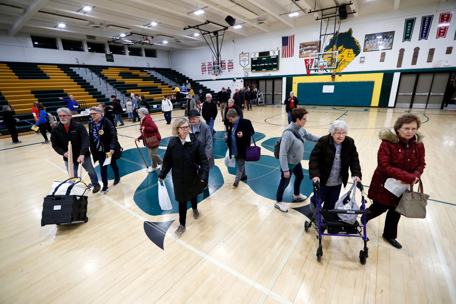 People walk to a caucus at a Des Moines high school.