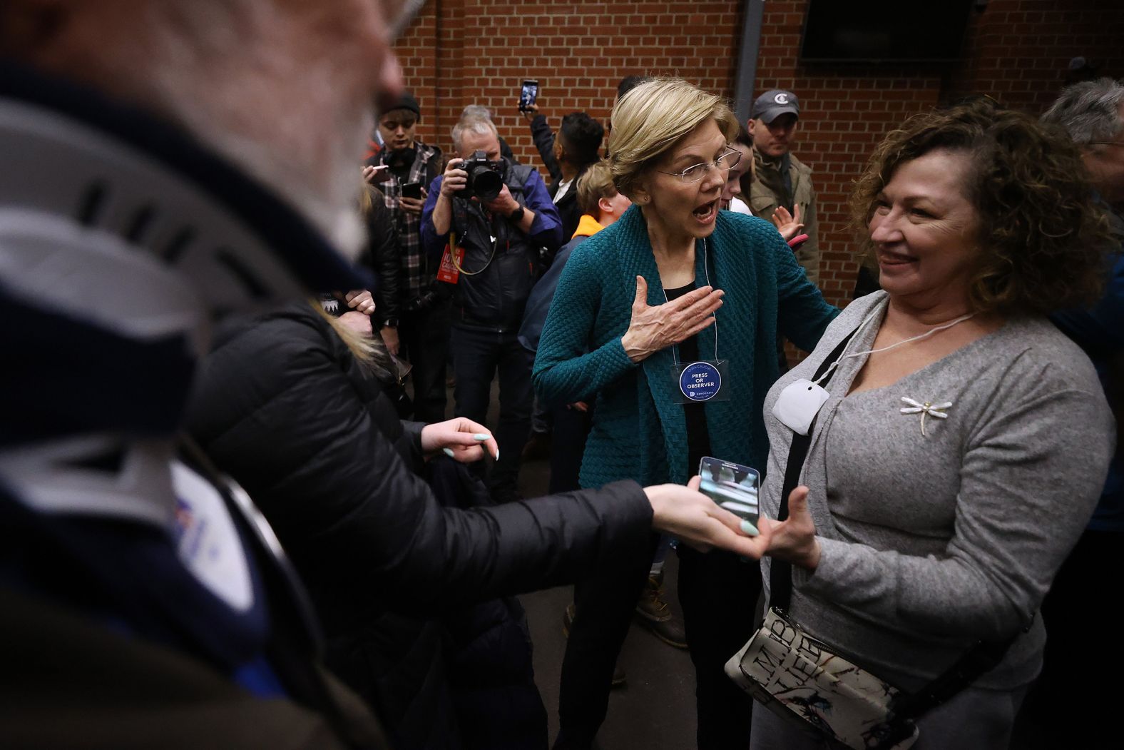 Warren visits caucusgoers at a high school in Des Moines.