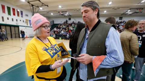 Elizabeth Hendrix, a precinct captain for Buttigieg, tries to persuade Tim Gannon to join her group at a caucus in Des Moines.