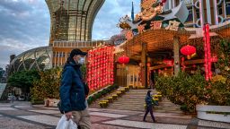 People wearing face masks walk in front of the Grand Lisboa Hotel on January 28, 2020 in Macao, China. 