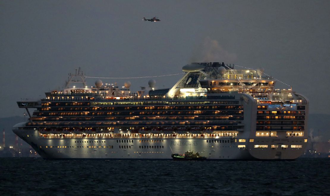 A small boat is pictured next to the Diamond Princess cruise ship as it sits anchored.