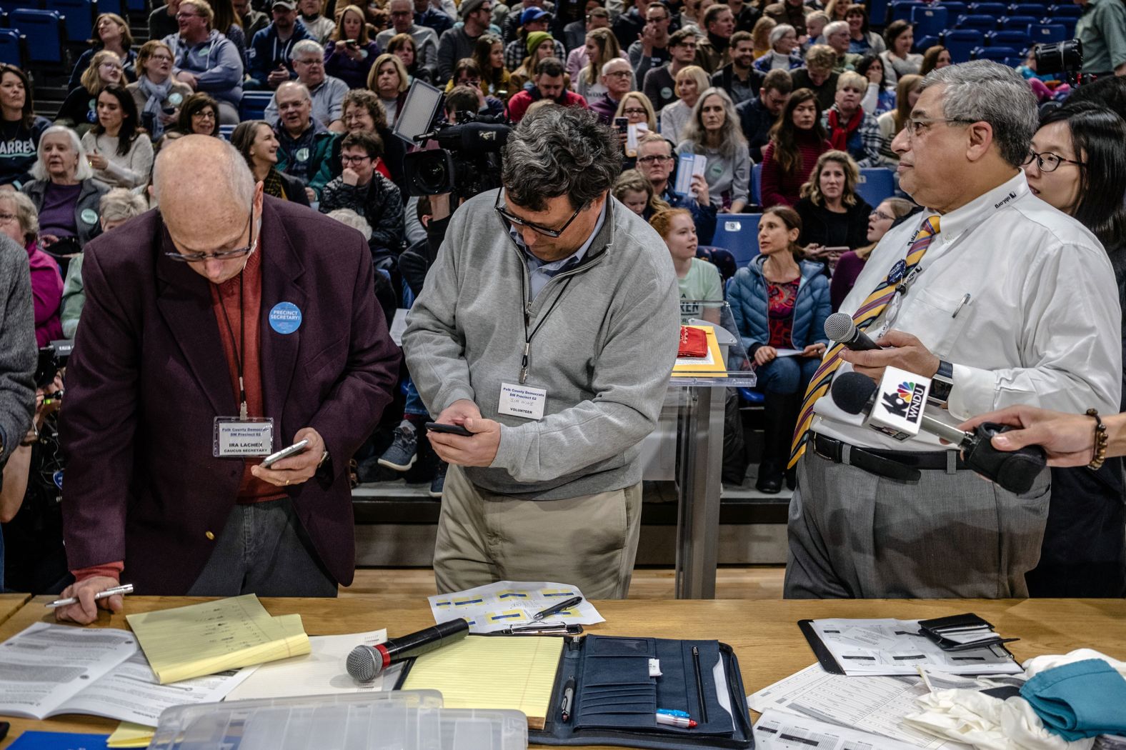 A precinct secretary and volunteer conduct an initial head count at a caucus site in Des Moines.