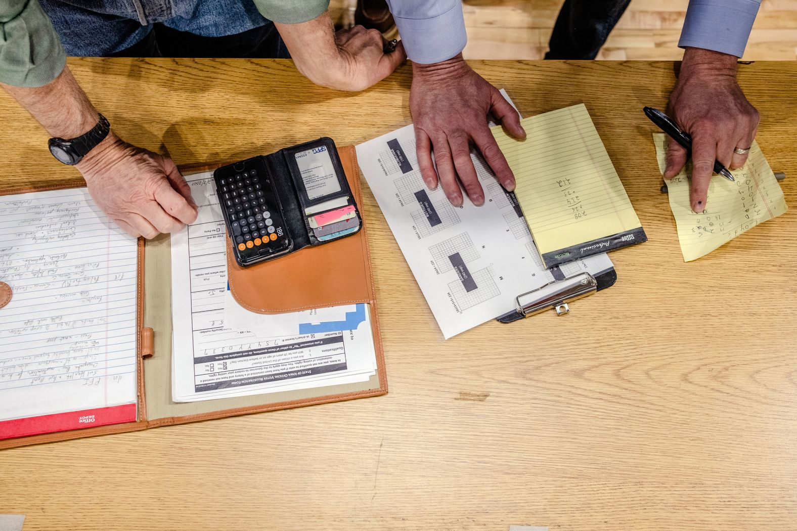 Officials tabulate the results of an initial head count at a caucus site in Des Moines on Monday, February 3.