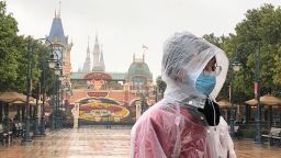 A Disney employee stands in front of the gates of the Shanghai Disney Resort.