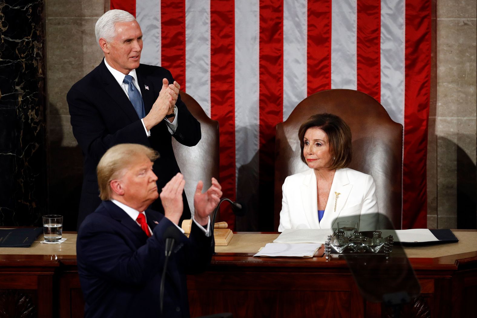 Pelosi remains seated while Trump and Pence applaud during the speech.