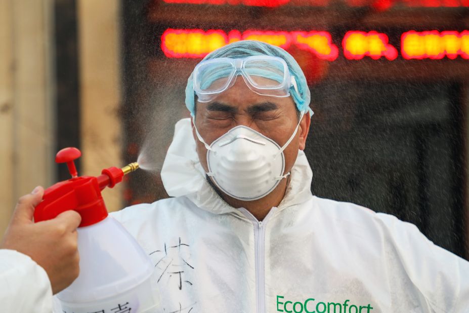 A colleague sprays disinfectant on a doctor in Wuhan on February 3.