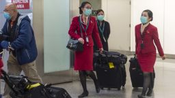 Cathay Pacific Airways cabin crew wearing face masks walk out of the international terminal at the San Francisco International Airport in Millbrae, California, United States on January 28, 2020. There are now 8,235 confirmed cases of coronavirus, with 171 death and 143 recovered. (Photo by Yichuan Cao/NurPhoto/Getty Images)