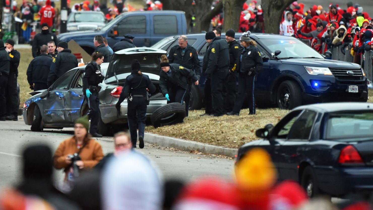 Police search a car after forcibly stopping it on the parade route for the Kansas City Chiefs in downtown Kansas City on Wednesday morning.