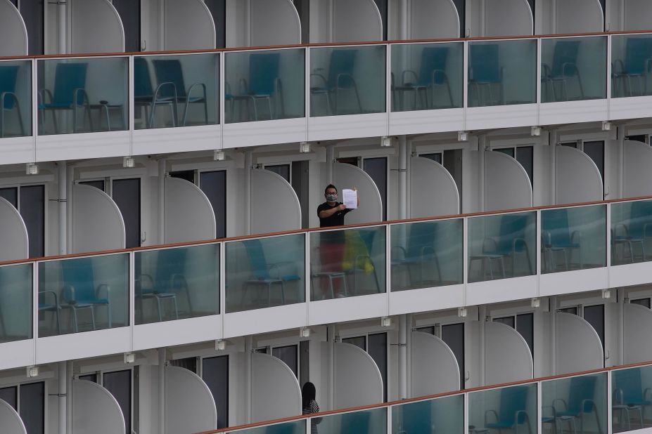 A passenger shows a note from the World Dream cruise ship docked at the Kai Tak cruise terminal in Hong Kong.