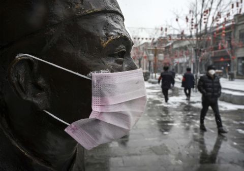 A mask is seen on a statue in Beijing on February 5.