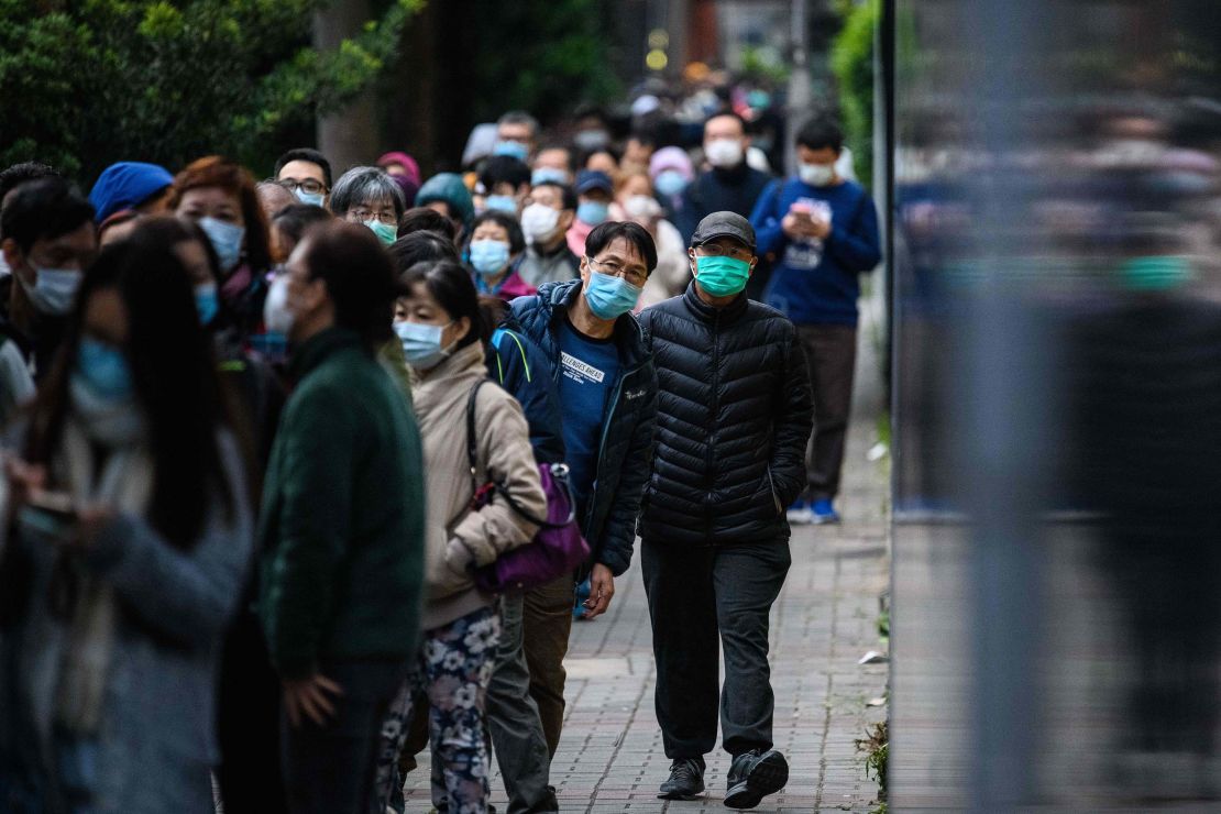People wearing face masks as a preventative measure following a coronavirus outbreak which began in the Chinese city of Wuhan, line up to purchase face masks in Hong Kong on February 5, 2020. 