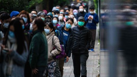 People wearing face masks as a preventative measure following a coronavirus outbreak which began in the Chinese city of Wuhan, line up to purchase face masks in Hong Kong on February 5, 2020. 