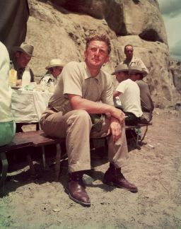 1951:  American actor Kirk Douglas sits at a picnic table on the desert location for director Billy Wilder's film, 'Ace In The Hole.'